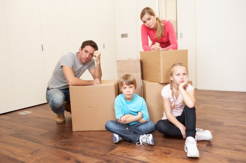 Professional movers carrying household furniture through a residential property